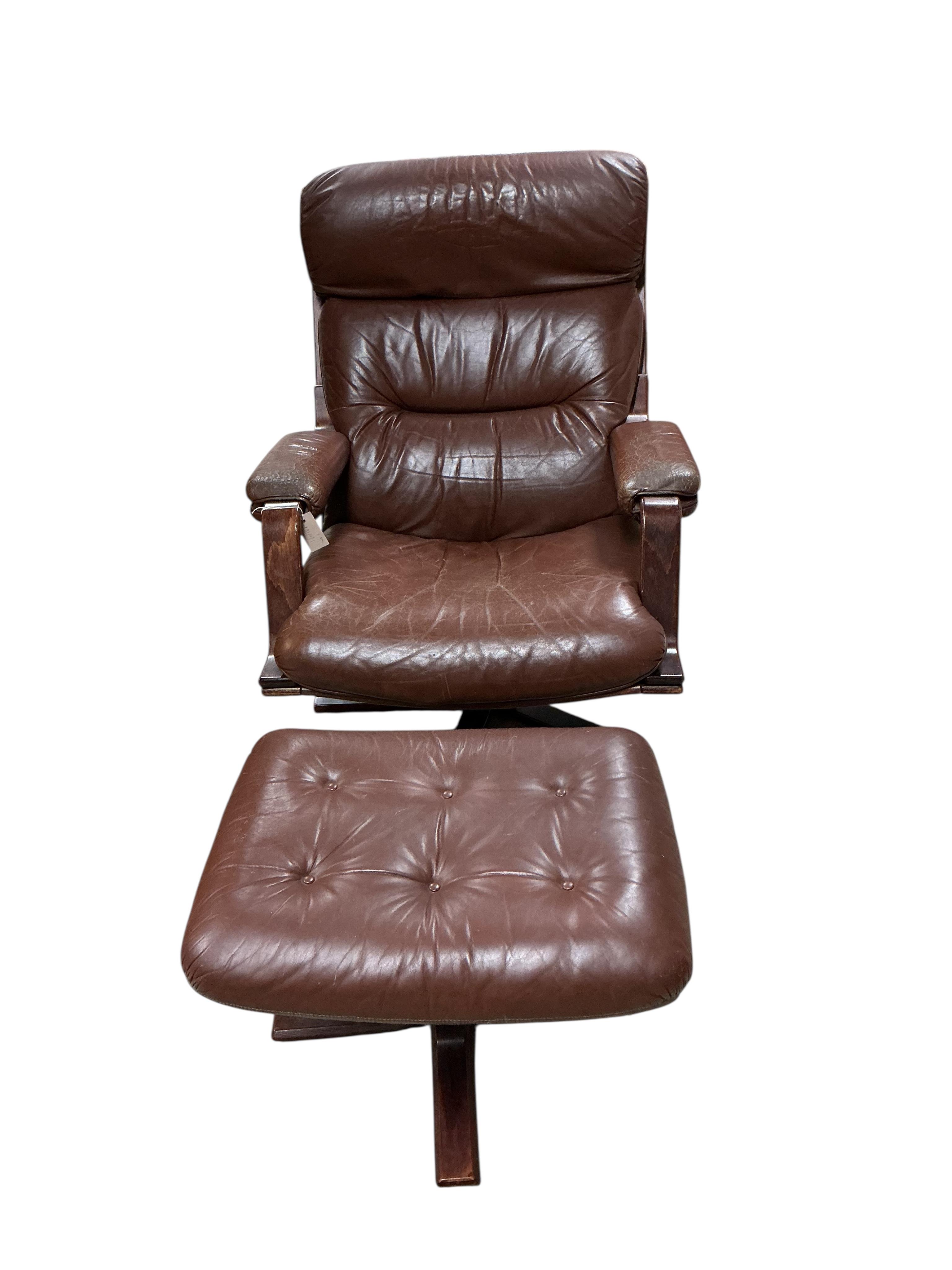 A mid century brown leather swivel chair, width 78cm, depth 90cm, height 96cm together with a footstool
